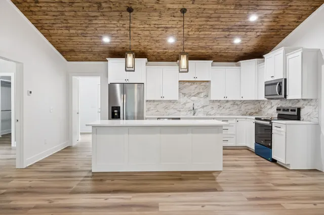 a kitchen with stainless steel appliances granite countertop a white stove top oven and cabinets