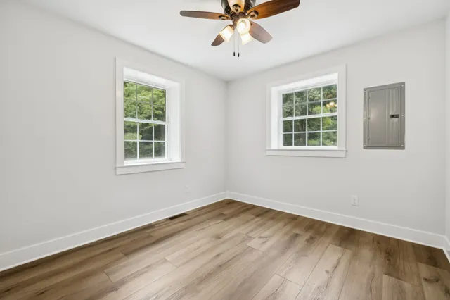 a view of a room with wooden floor and windows