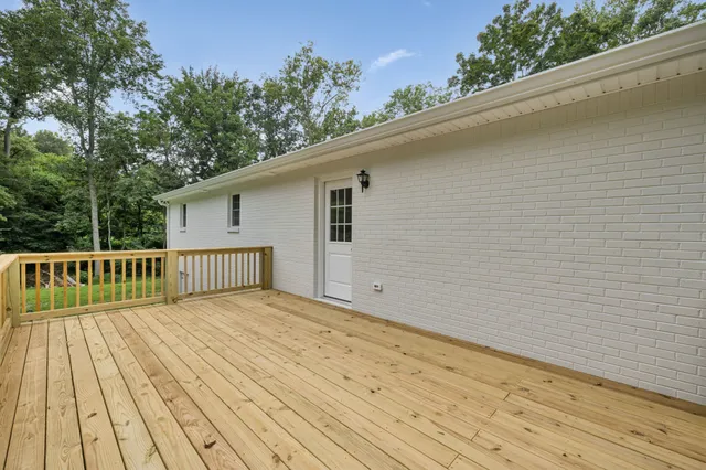 a view of balcony with wooden floor and fence