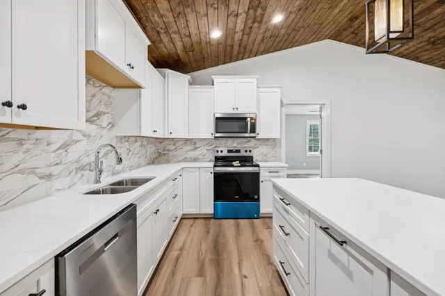 a kitchen with granite countertop a sink stainless steel appliances a counter space and cabinets