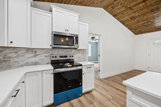 a kitchen with granite countertop cabinets stainless steel appliances and wooden floor