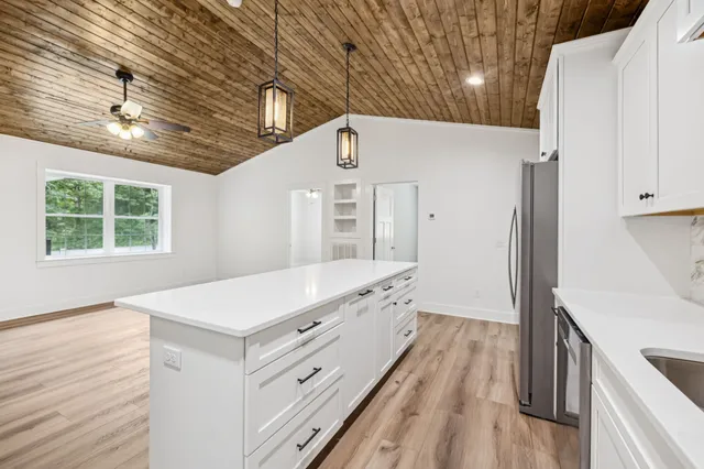 a kitchen with a stove and a wooden floor