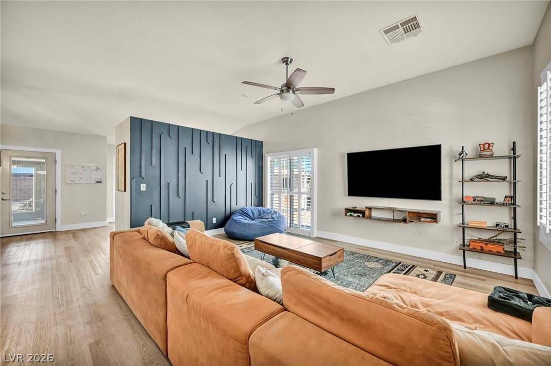 1234 Sunfire Street Henderson, NV 89014 - Photo 4 of 40 Step into a sun-filled living space featuring vaulted ceilings and rich wood flooring.