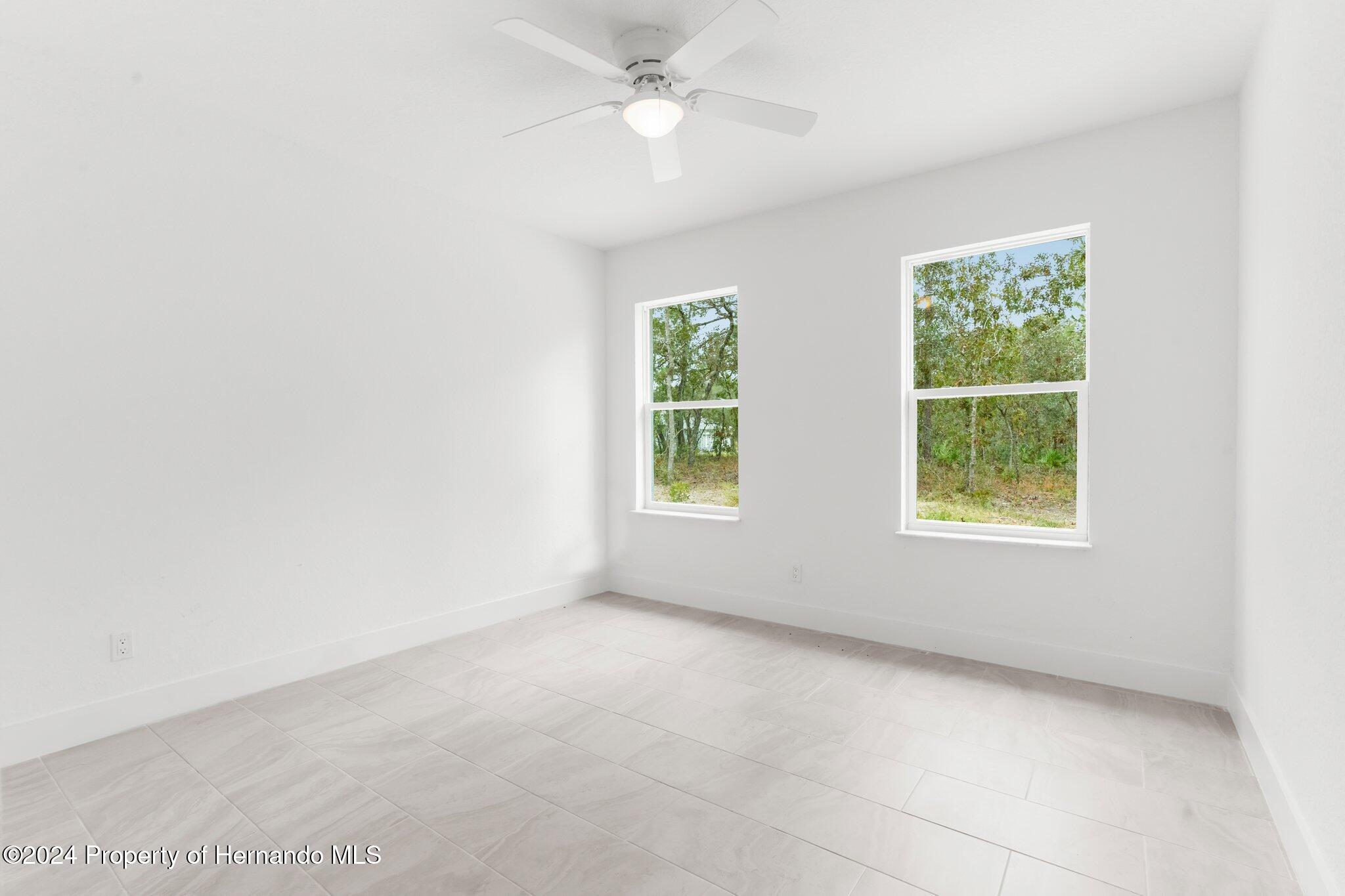 15214 Mt Sparrow Road Brooksville, FL 34614 - Photo 14 of 36 an empty room with windows and fan