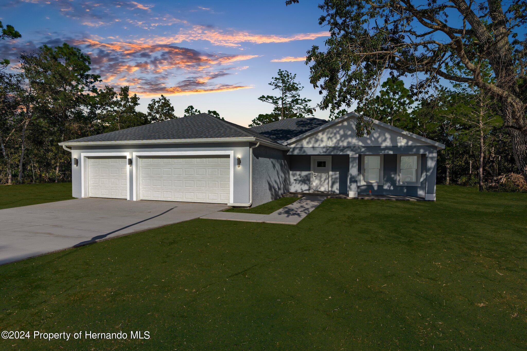 15214 Mt Sparrow Road Brooksville, FL 34614 - Photo 18 of 36 a front view of a house with a garden and porch