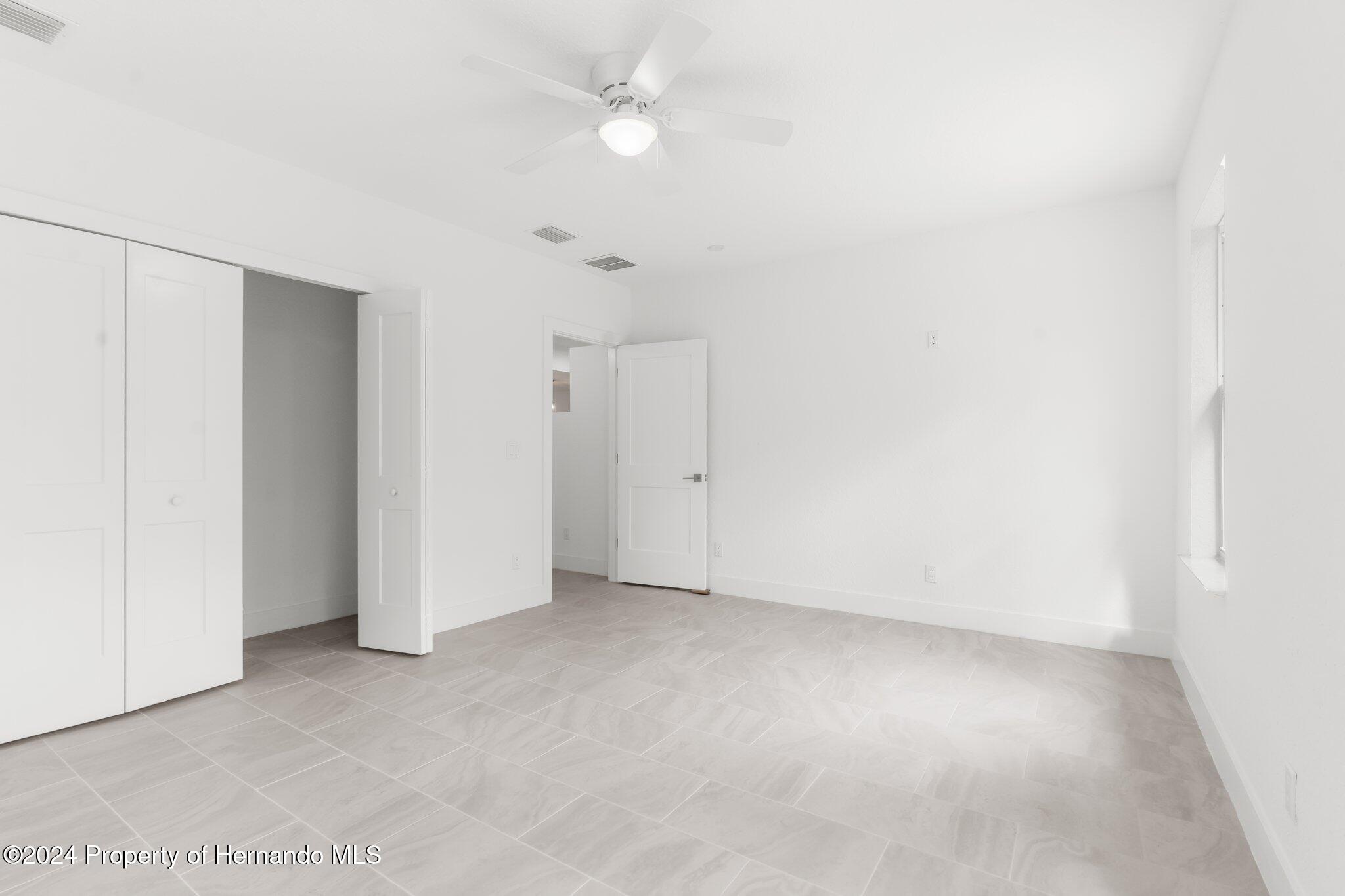 15214 Mt Sparrow Road Brooksville, FL 34614 - Photo 24 of 36 an empty room with an entryway and fan
