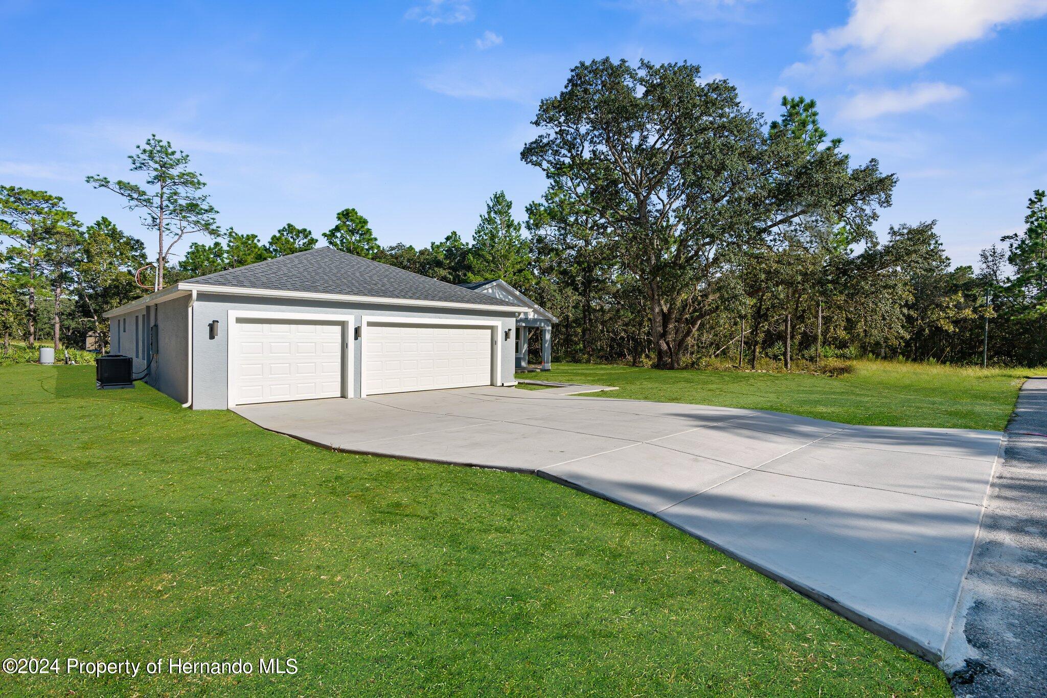 15214 Mt Sparrow Road Brooksville, FL 34614 - Photo 35 of 36 a front view of a house with a yard and garage