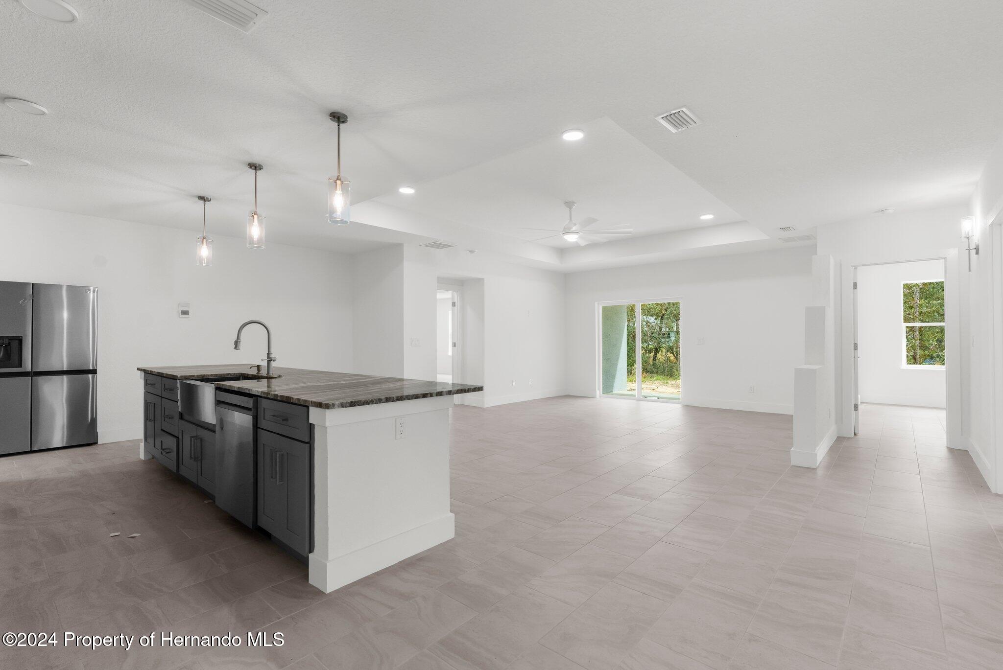 15214 Mt Sparrow Road Brooksville, FL 34614 - Photo 7 of 36 a large kitchen with stainless steel appliances granite countertop a stove and a sink