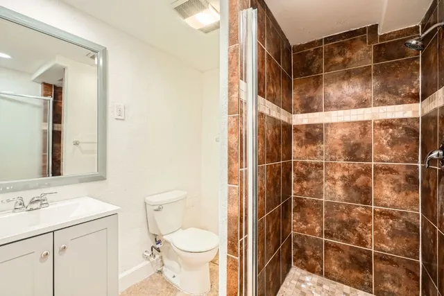 a bathroom with a shower toilet and sink