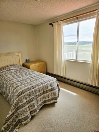 a bedroom with a bed chair and window