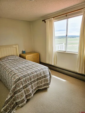 a bedroom with a bed chair and window