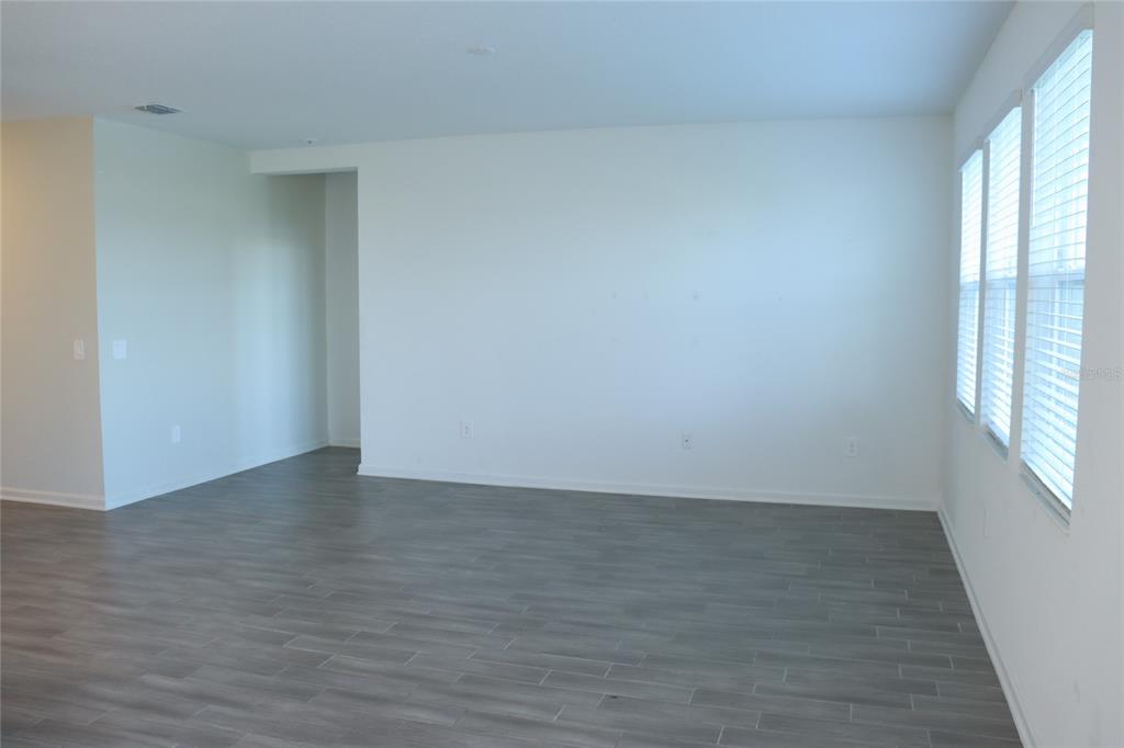 34558 Shellback Street Leesburg, FL 34788 - Photo 13 of 36 a view of an empty room with wooden floor and a window