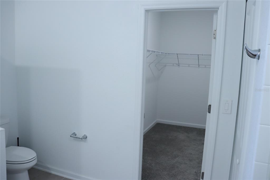 34558 Shellback Street Leesburg, FL 34788 - Photo 18 of 36 a bathroom with a granite countertop toilet and a sink