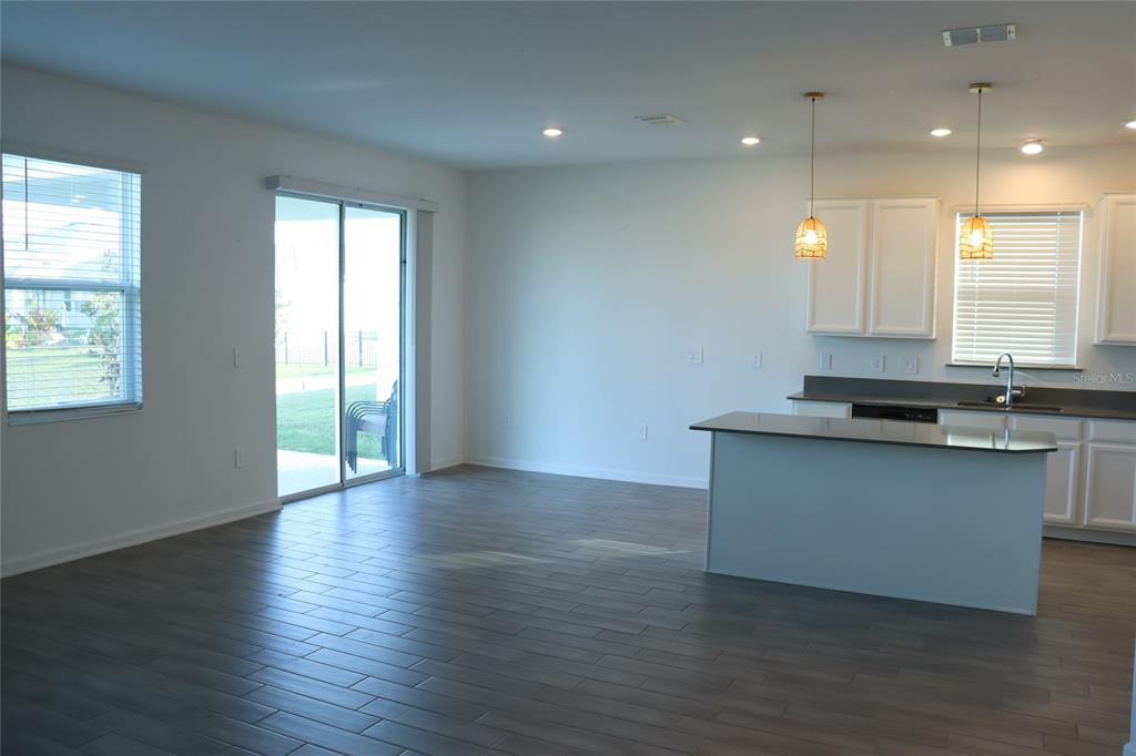 34558 Shellback Street Leesburg, FL 34788 - Photo 8 of 36 a view of kitchen with granite countertop window and wooden floors
