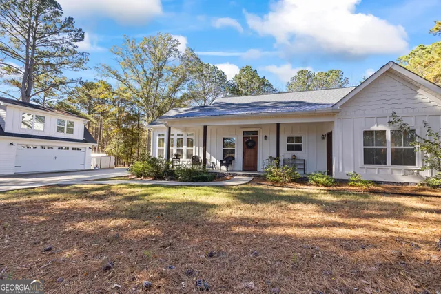 a view of a house with backyard and sitting area