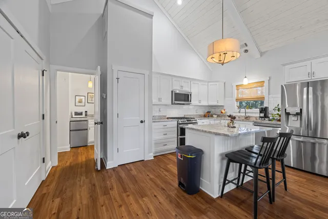 a kitchen with stainless steel appliances granite countertop a stove a sink dishwasher and microwave with wooden floor