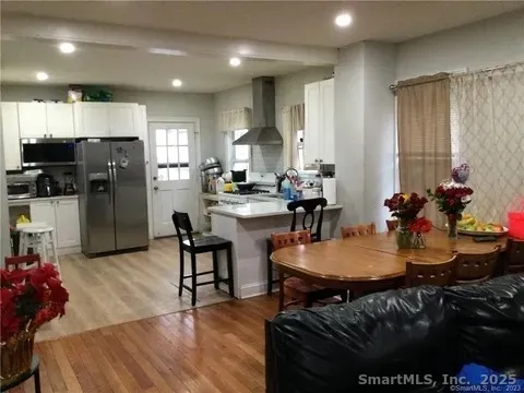 a kitchen with sink refrigerator dining table and chairs