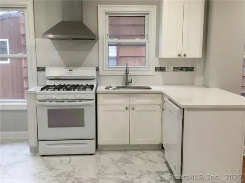 368 Lenox Avenue Bridgeport, CT 06605 - Photo 5 of 7 a kitchen with white cabinets and white appliances