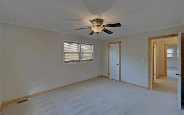 a view of a room with a ceiling fan and a window