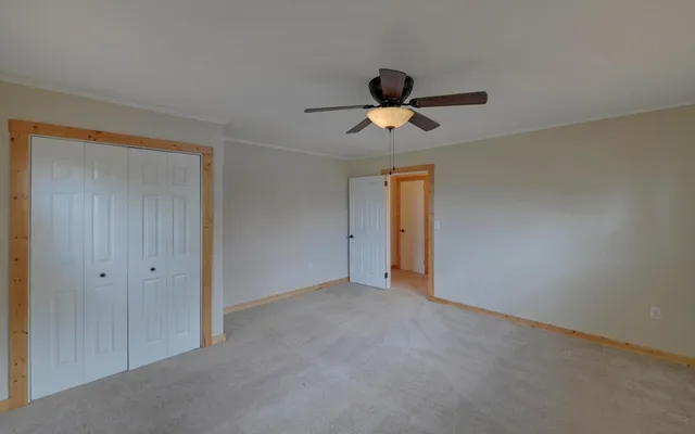 a view of an empty room and a ceiling fan