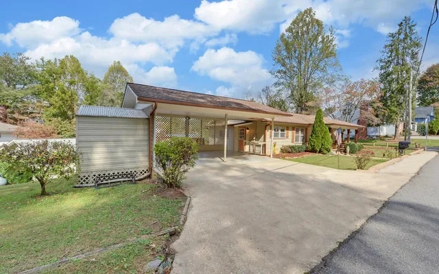 a view of a house with a big yard and large trees