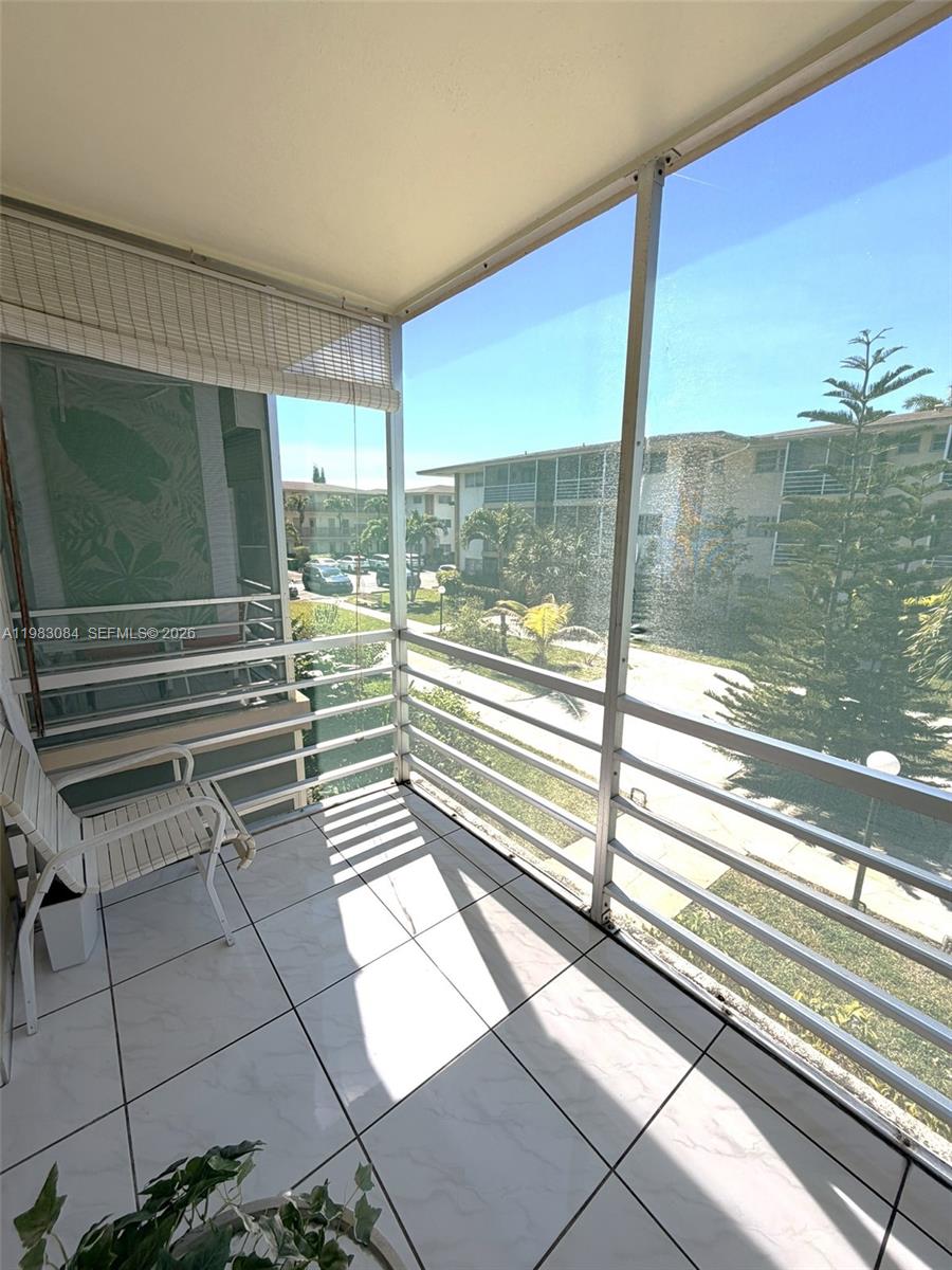 17000 Northeast 14th Avenue, Unit 206 Miami, FL 33162 - Photo 11 of 15 a view of a balcony with floor to ceiling windows with wooden floor