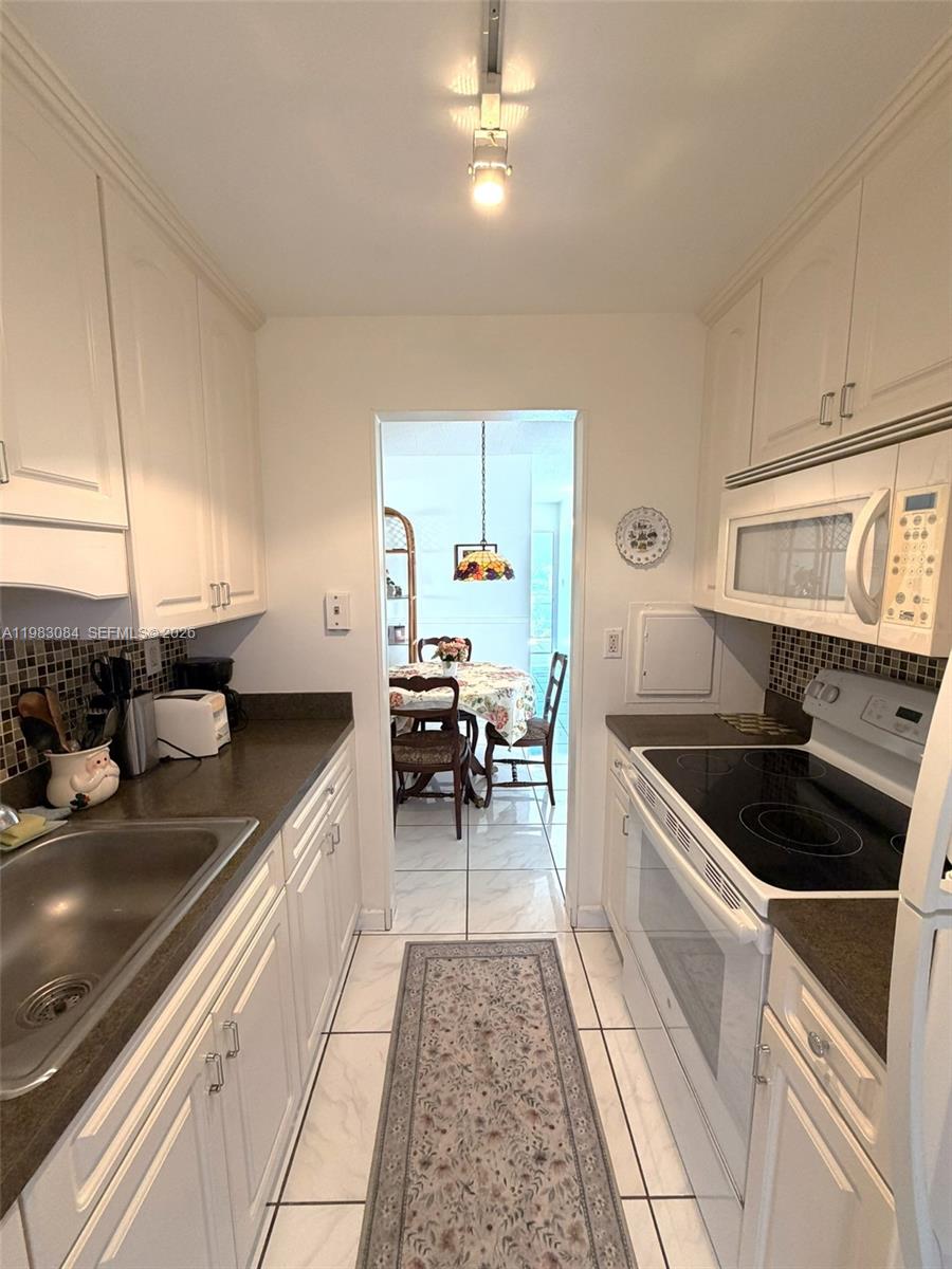 17000 Northeast 14th Avenue, Unit 206 Miami, FL 33162 - Photo 5 of 15 a kitchen with a sink and a stove top oven