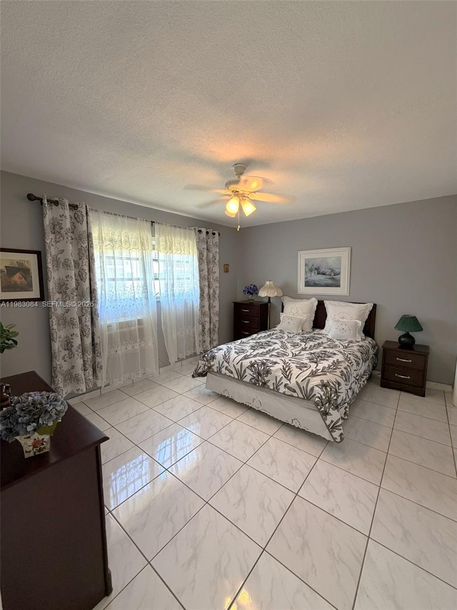 17000 Northeast 14th Avenue, Unit 206 Miami, FL 33162 - Photo 8 of 15 a bedroom with a bed and a potted plant on dresser