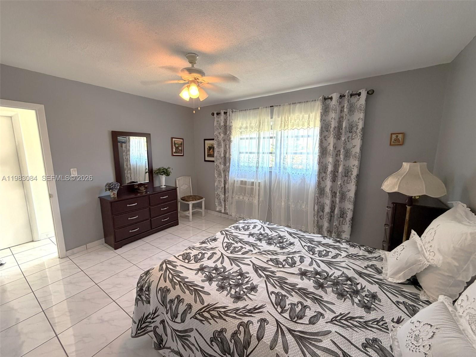 17000 Northeast 14th Avenue, Unit 206 Miami, FL 33162 - Photo 9 of 15 a bed room with a bed mirror and a window