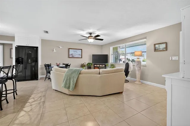 a living room with couches and kitchen view with wooden floor
