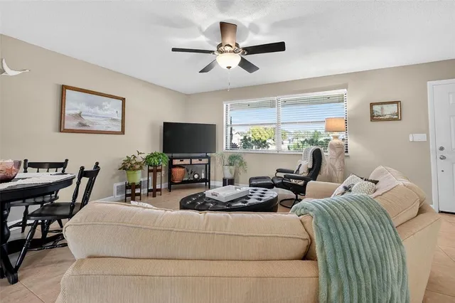 a living room with furniture a flat screen tv and a window