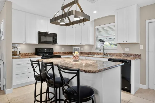 a kitchen with stainless steel appliances granite countertop a sink a stove a microwave a refrigerator and cabinets