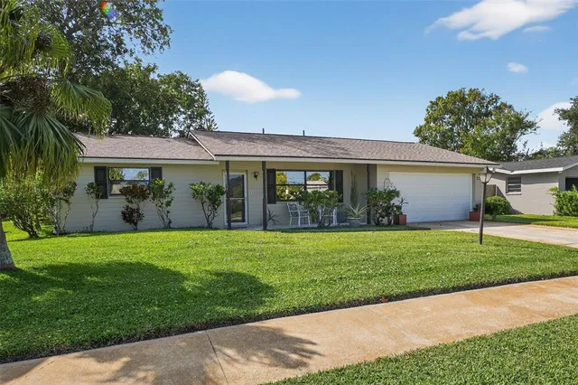 a front view of a house with a yard and potted plants