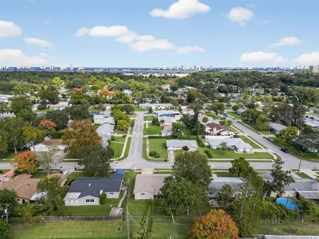 an aerial view of residential houses with outdoor space and ocean view
