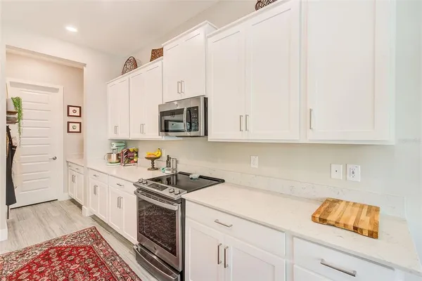 a kitchen with granite countertop white cabinets and stainless steel appliances
