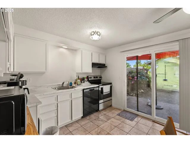 a kitchen with a sink a counter top space and stainless steel appliances