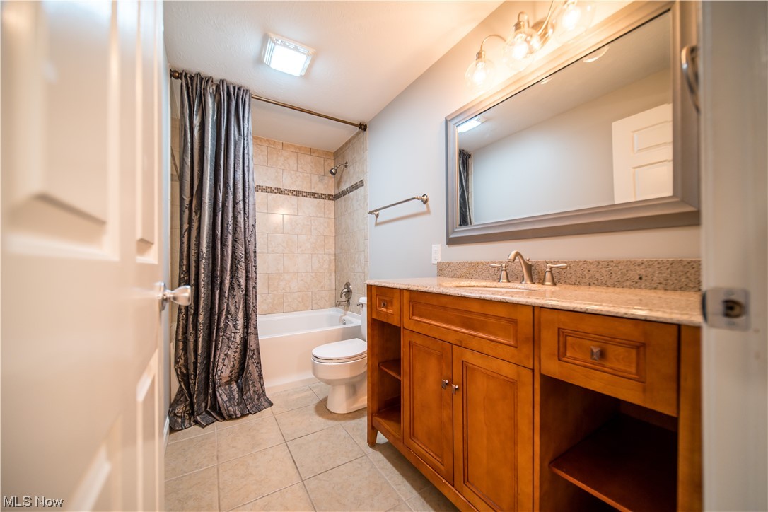 129 Quaker Ridge Drive Akron, OH 44313 - Photo 13 of 20 Full bathroom featuring tile floors, shower / tub combo, vanity, and toilet