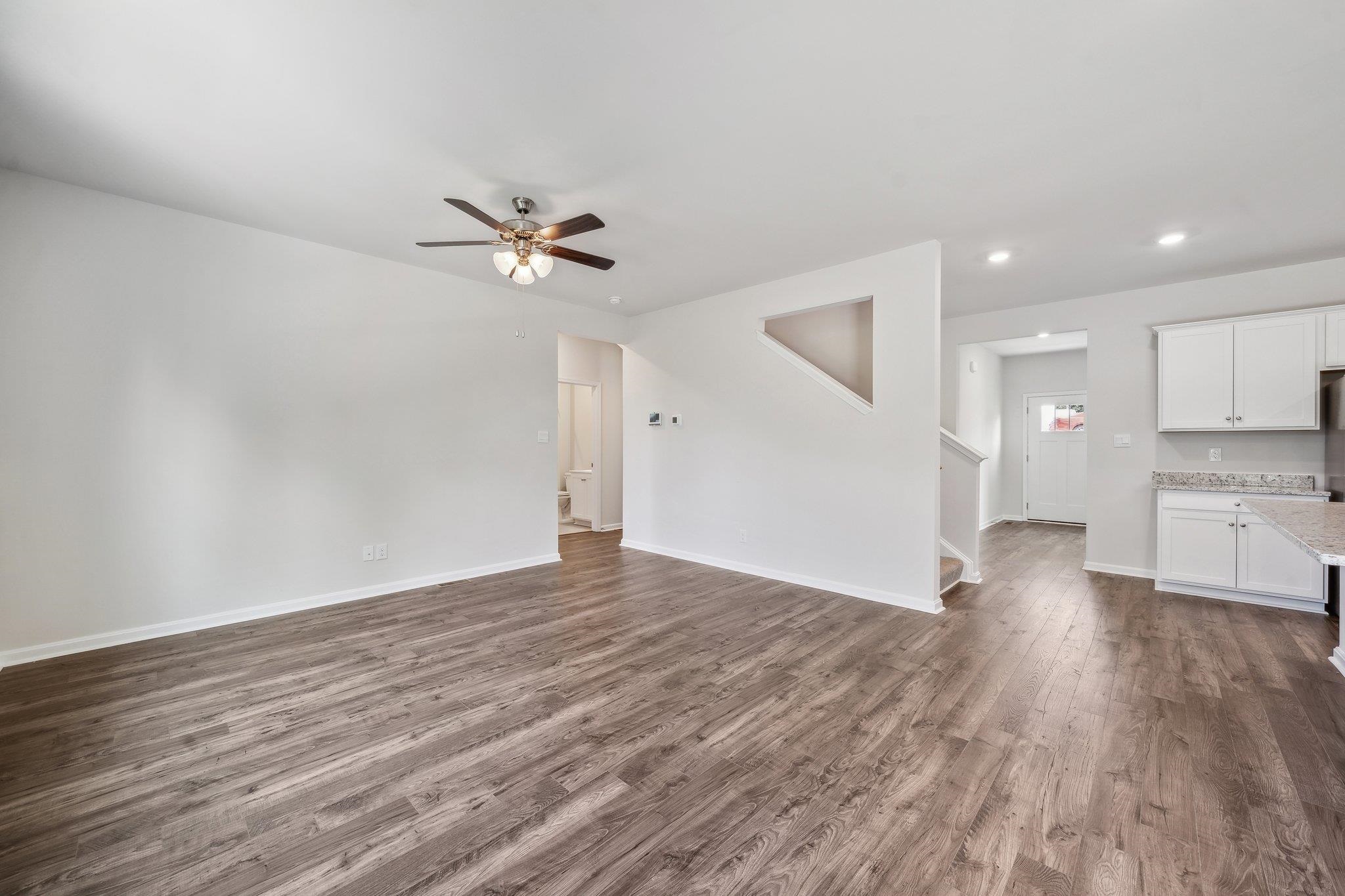 240 Waterfront Drive Raphine, VA 24472 - Photo 11 of 29 a view of an empty room with a kitchen and a ceiling fan