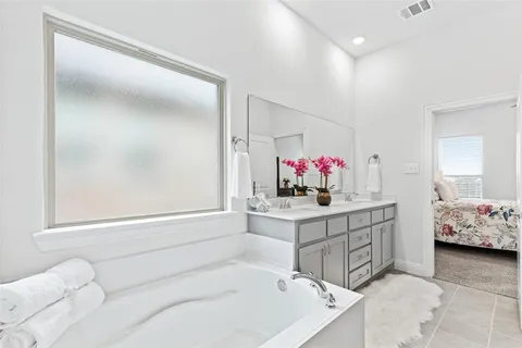 a bathroom with a tub sink and mirror