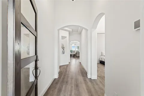 a view of a hallway with wooden floor and staircase