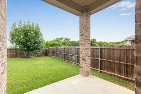 a view of a backyard with a small cabin and wooden fence