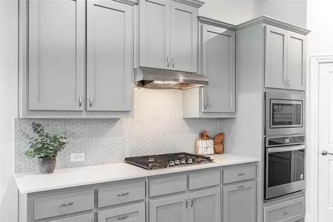 a kitchen with stainless steel appliances granite countertop a refrigerator and white cabinets