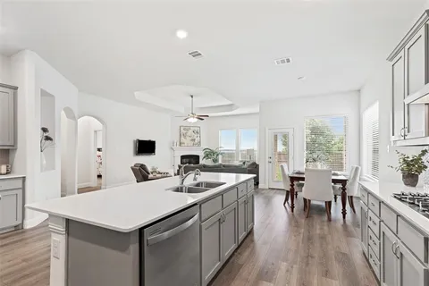 a large kitchen with a table chairs stove and wooden floor