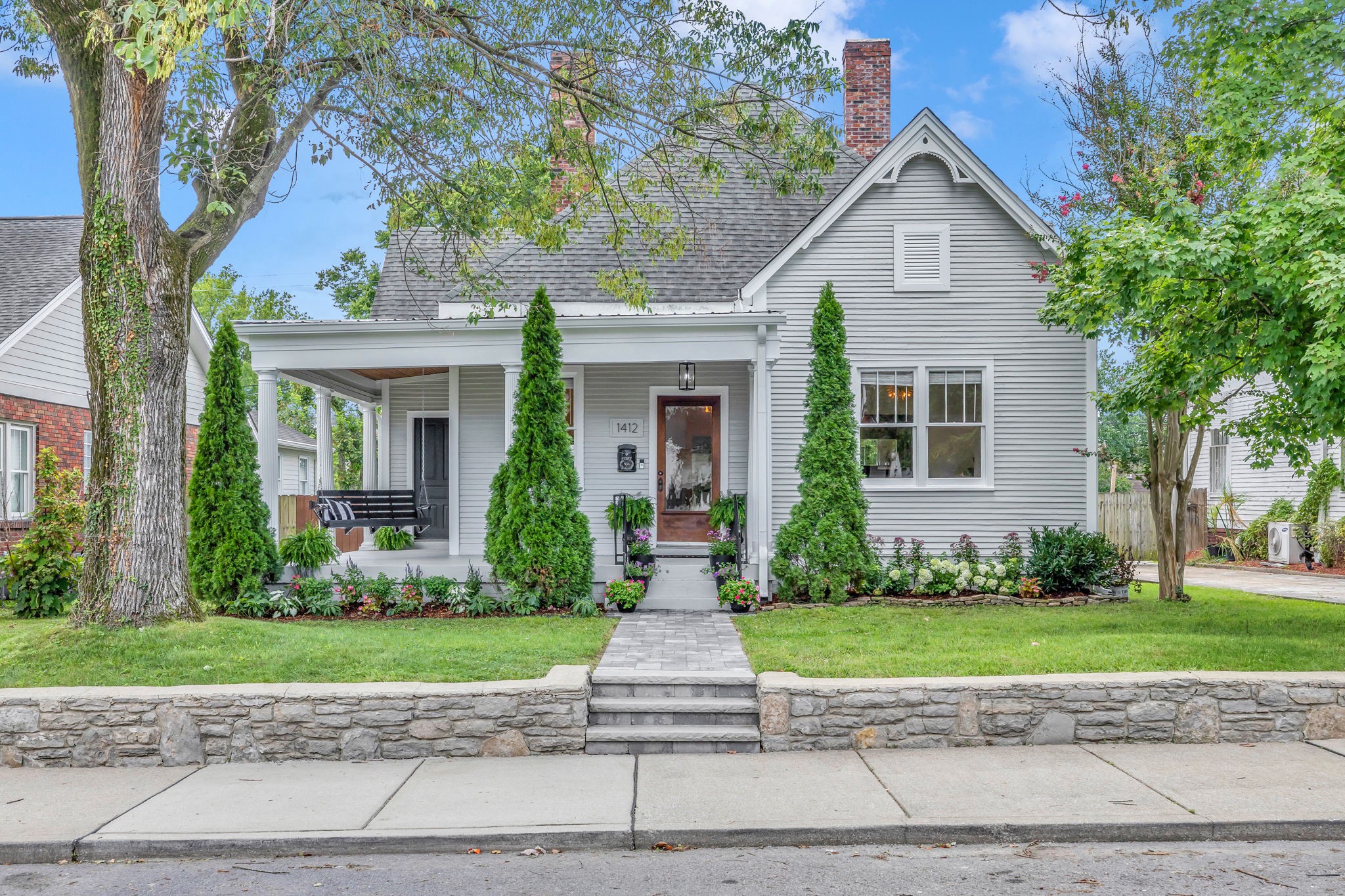 a front view of a house with a yard and potted plants