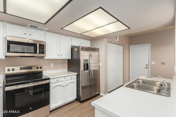 a kitchen with stainless steel appliances a stove microwave and sink