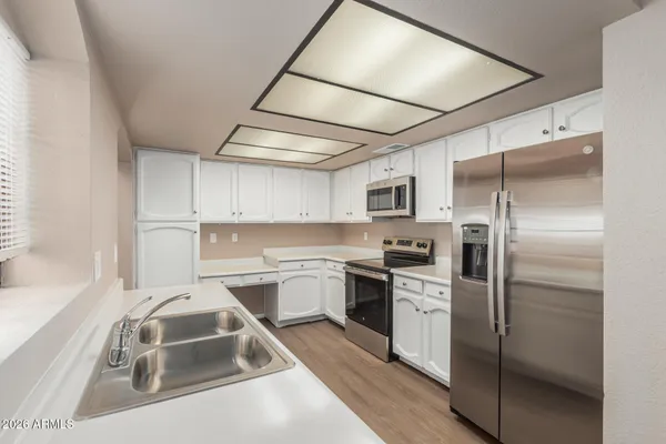 a kitchen with a sink appliances and cabinets