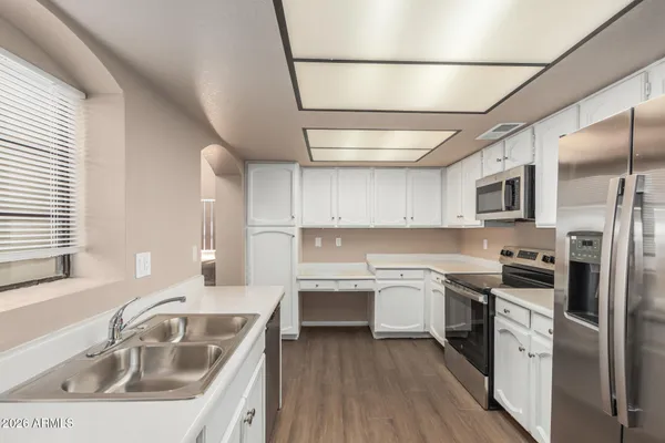 a kitchen with a sink stove cabinets and refrigerator
