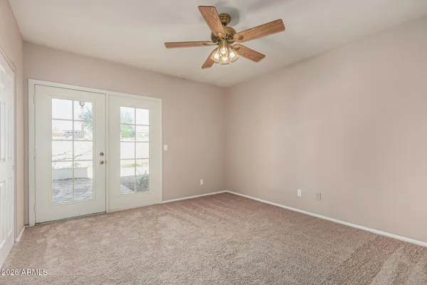 an empty room with windows and fan