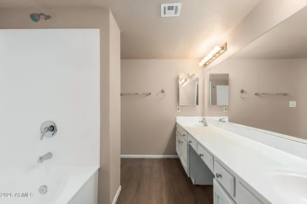 a bathroom with a double vanity sink and mirror with shower