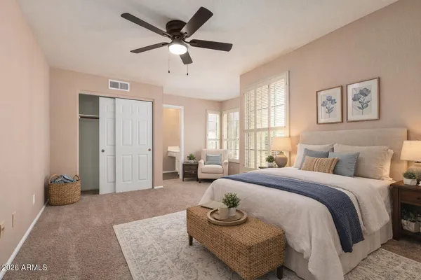 a spacious bedroom with a bed and a chandelier